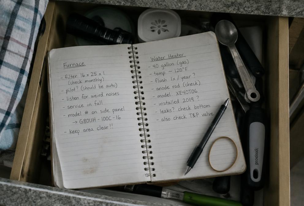 A handwritten notebook open in a kitchen drawer